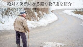 雪景色の道を歩く老人
