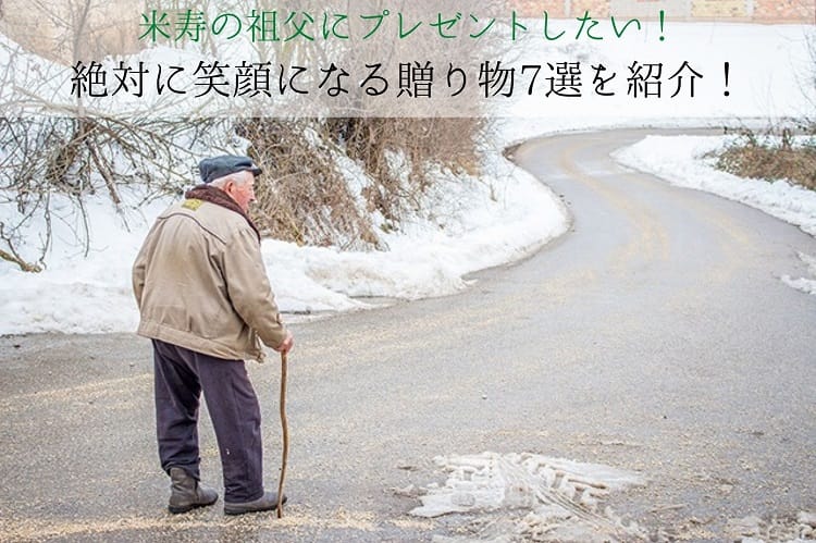 雪景色の道を歩く老人