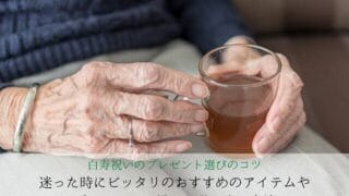 グラスに入ったお茶を持つ老婆の手