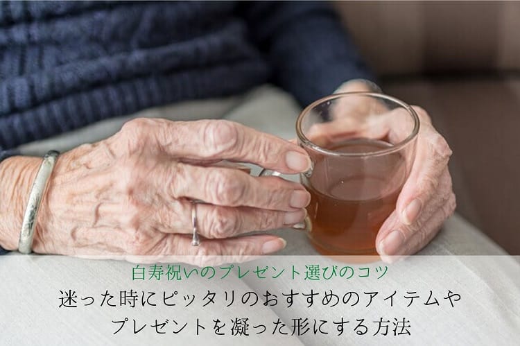 Main de vieille femme tenant un verre de thé