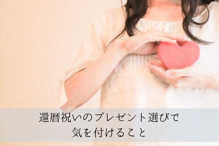 ハート型の板を胸のあたりで持っている女性