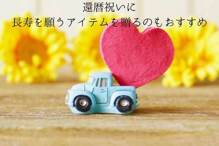 ミニチュアの車の上に木製の赤いハートの小物が乗っかっている