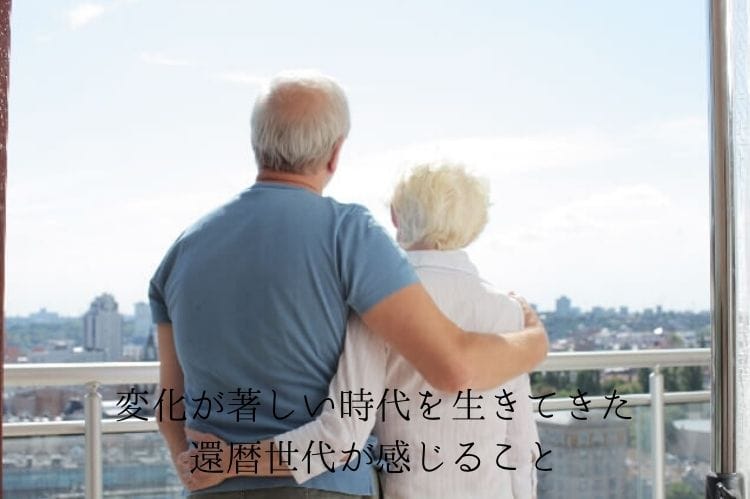 シニア夫婦が窓辺で寄り添っている後ろ姿