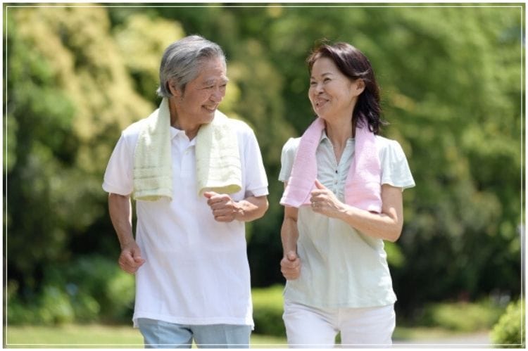 シニア夫婦が会話をしながらウォーキングしている様子