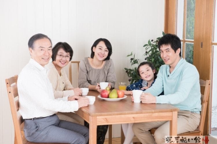 二世帯の家族がテーブルに座り話をしている様子