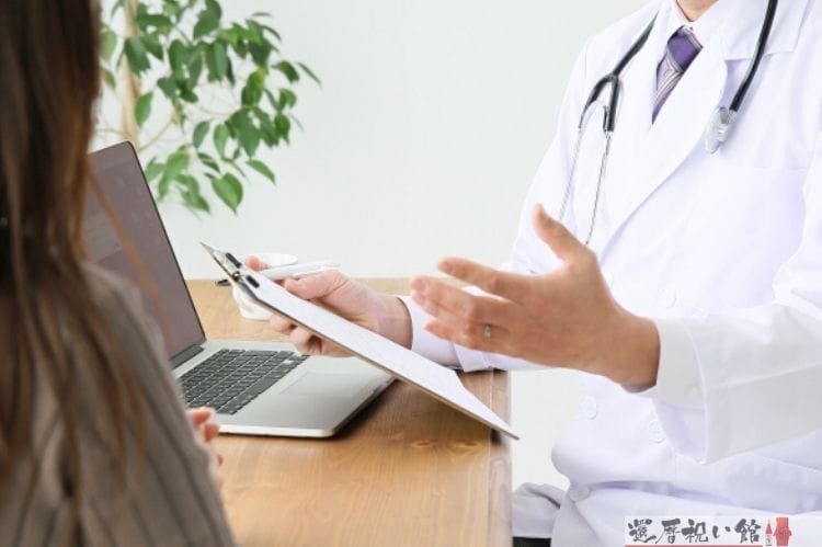 医師がカルテを持ちながら患者に話をしている様子