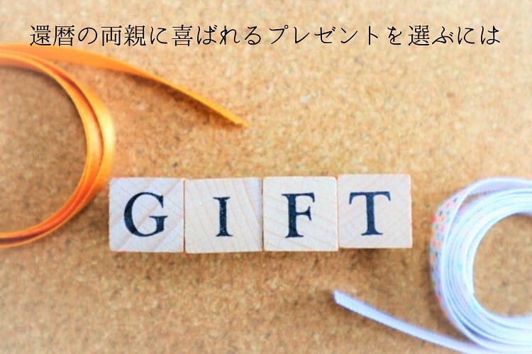 GIFTと書かれた木の雑貨とその周りに置かれたオレンジ色や水玉のリボン