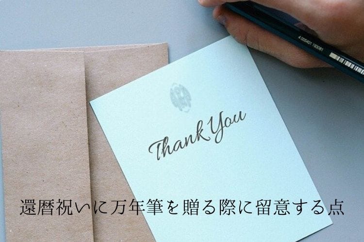 茶色の封筒の上に乗った白いカードに鉛筆でthank youと書かれている