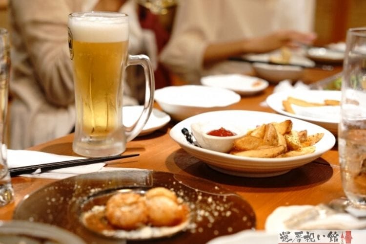 飲食店・居酒屋で複数人が食事をしながら座っている様子