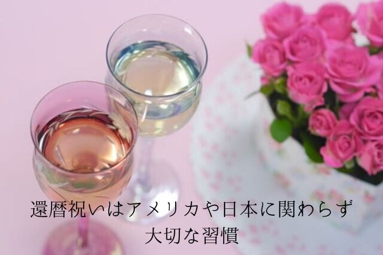 ピンクの薔薇の花束の隣にある白ワインが入った二つの小さなグラス
