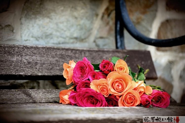 赤や薄いオレンジ色の薔薇の花束