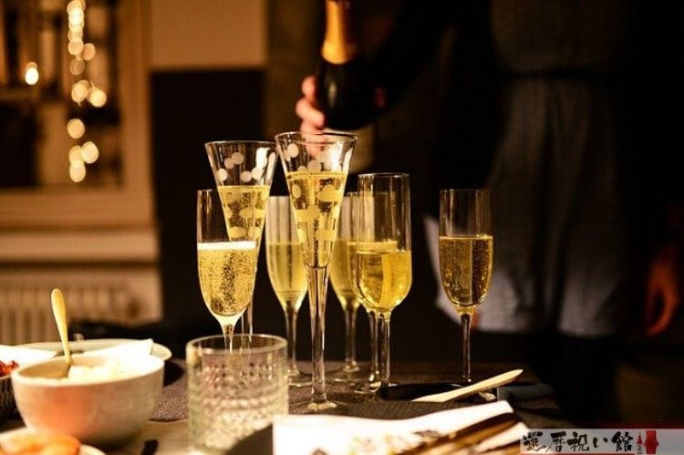 テーブルの上にシャンパンが入った大小大きさの違うグラスがいくつか置かれている