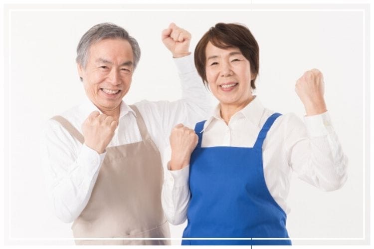 シニア夫婦がエプロンをつけてやる気を起こしている様子