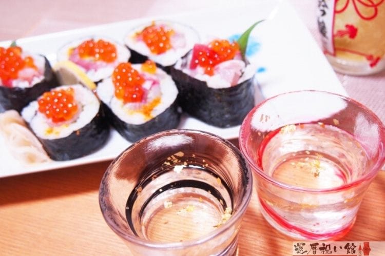 2つの日本酒が入ったグラスといくらが入った巻きずし
