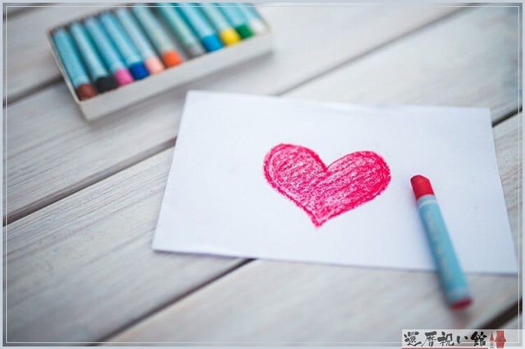 白い紙に赤いクレヨンでハートを描いた後の様子