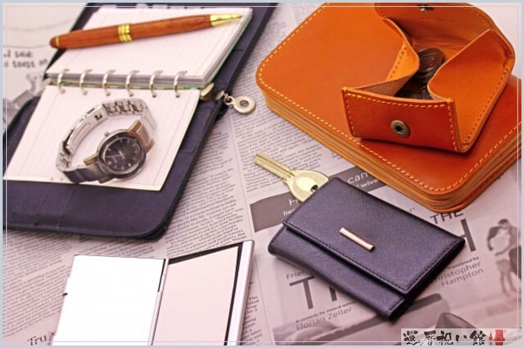 財布やキーケース、腕時計や手帳、ペンなどが無造作に置かれている