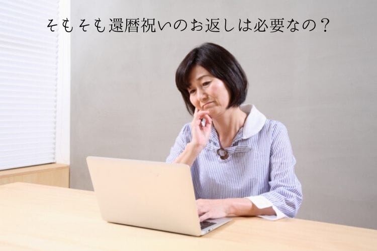 シニアの女性がノートパソコンを打ちながら首をかしげている様子