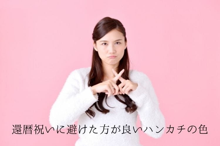 白い服を着た若い女性が指でバツサインをしている様子