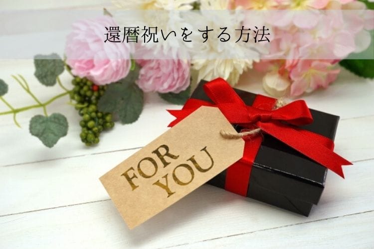 黒い箱に赤いリボン、for youと書かれたメッセージタグがついているギフトボックス