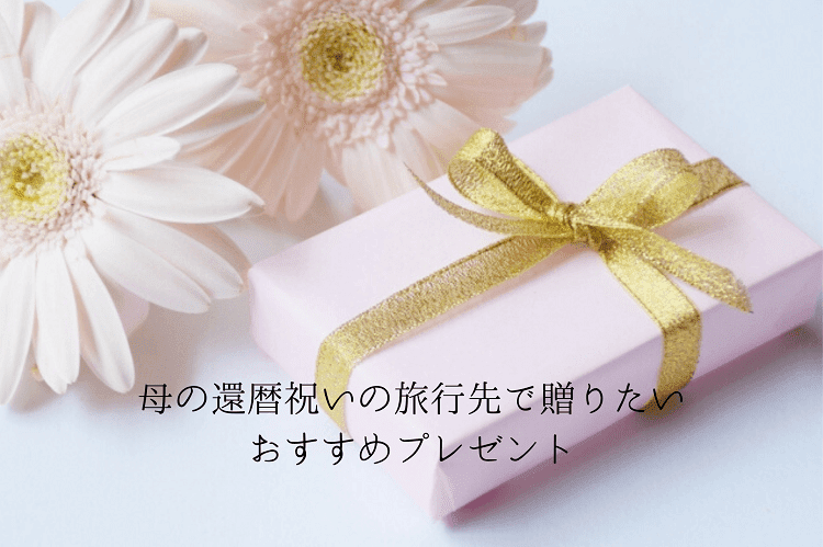 ピンクの包みにゴールドのリボンがついたプレゼントボックスとピンクの花