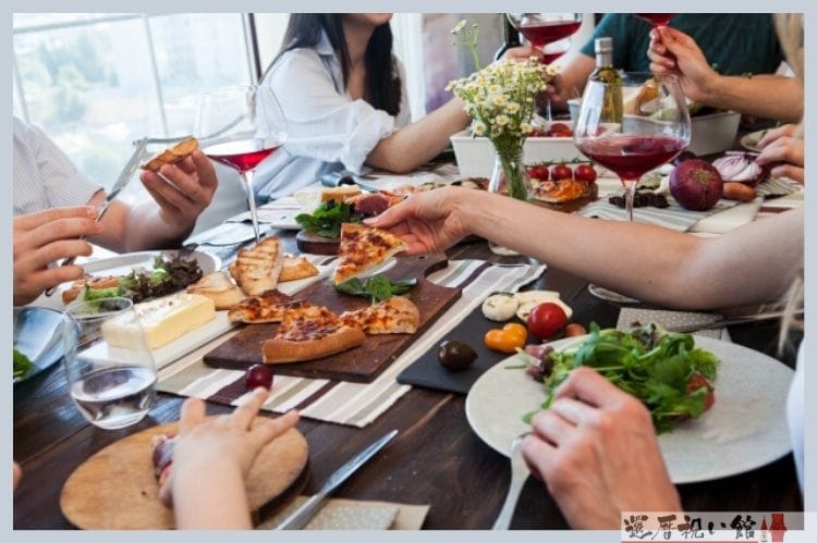 ピザやサラダなどをテーブルで食べている海外の昼ご飯