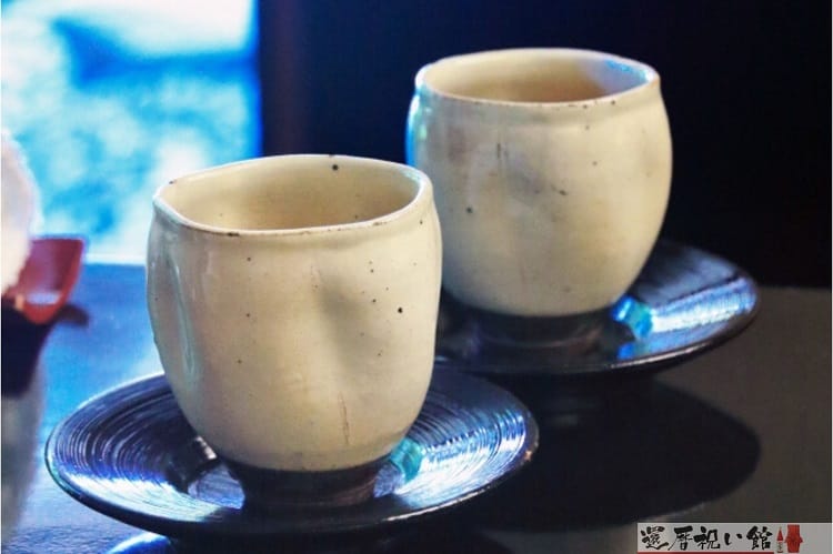 手作りの味わいが感じられるベージュ色の陶器の湯呑