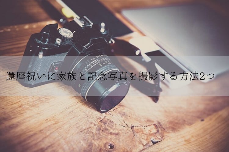 一眼レフカメラとスマホが木のテーブルに置かれている