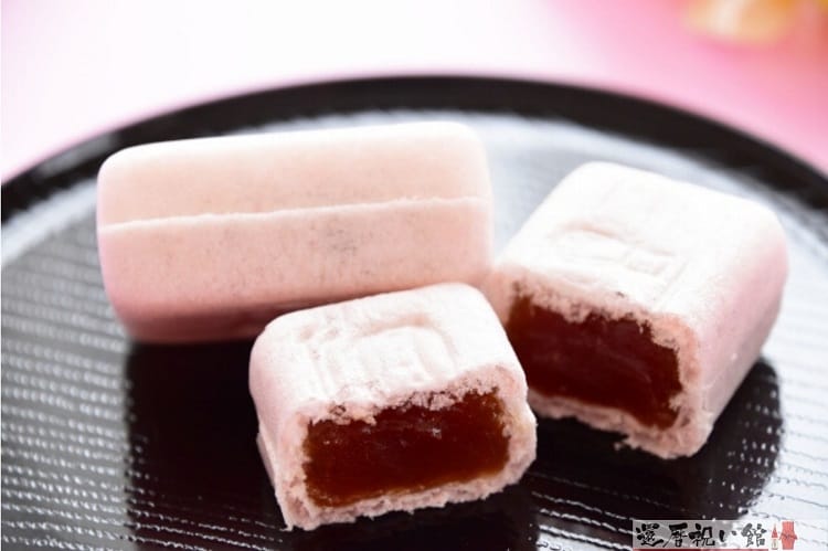 ピンクの最中が2つ黒い小さなお盆に乗せられている