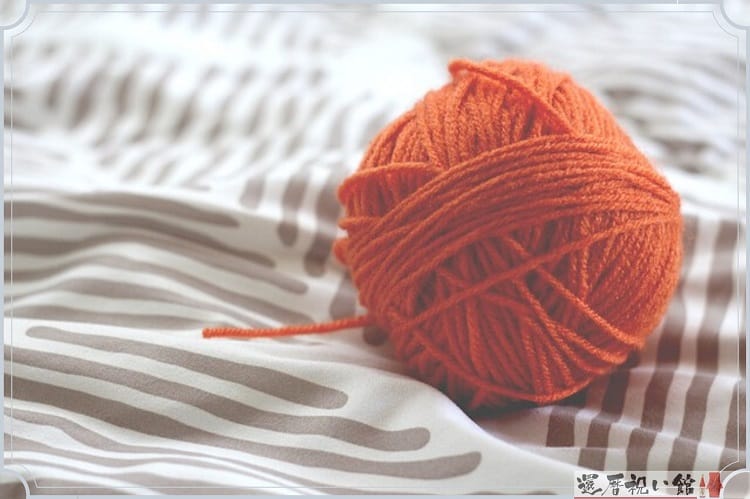 オレンジ色の毛糸を丸く巻いたもの