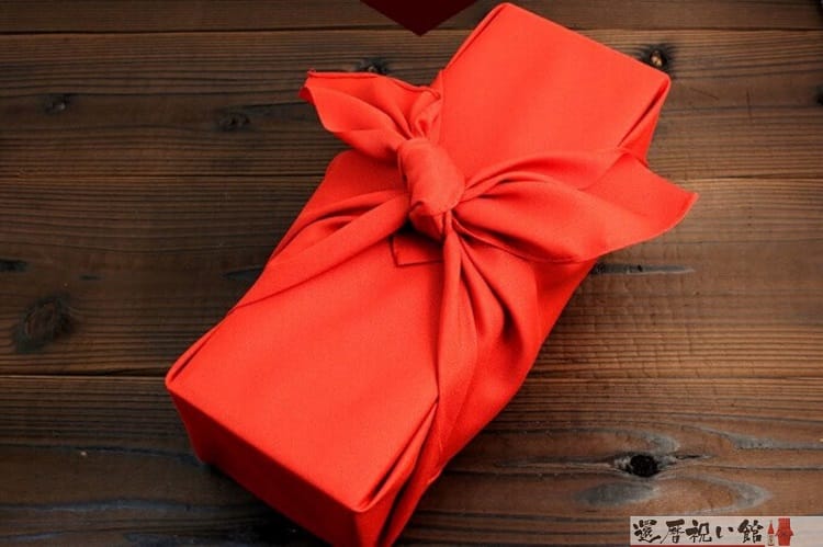 お酒が入ったギフトの箱が赤い布で包んである