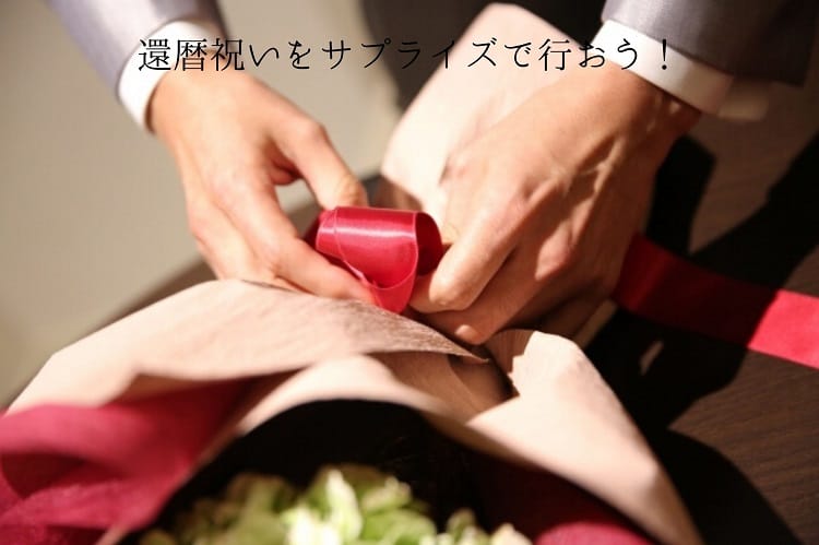花束に赤いリボンをつけるスーツを着た男性