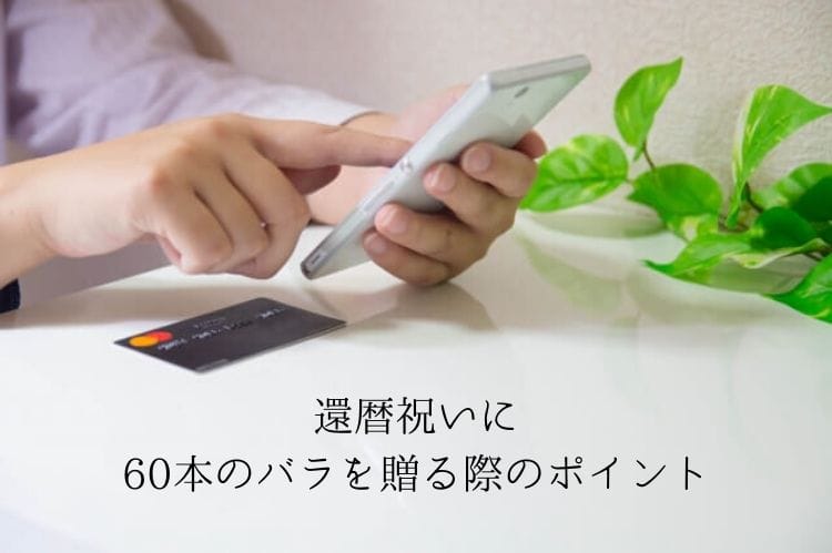 クレジットカードをテーブルに置きスマホをタップして買い物している様子