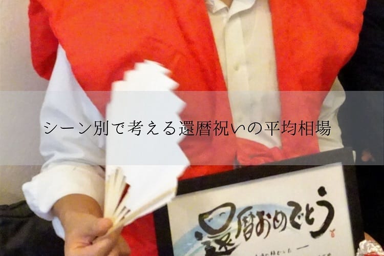 還暦おめでとうと書かれたフォトフレームと扇子を持ち、赤いちゃんちゃんこを着た還暦を迎えたシニア男性