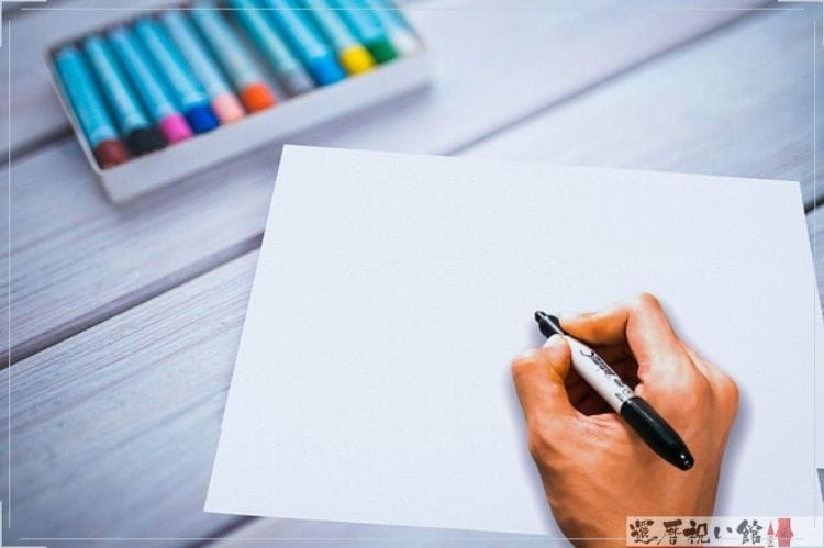 白い紙に黒の水性マーカーで何かを書こうとしている様子
