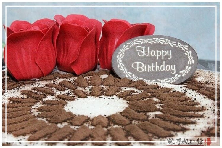happy birthdayと書かれたチョコレートと3つの薔薇が乗ったチョコレートケーキ