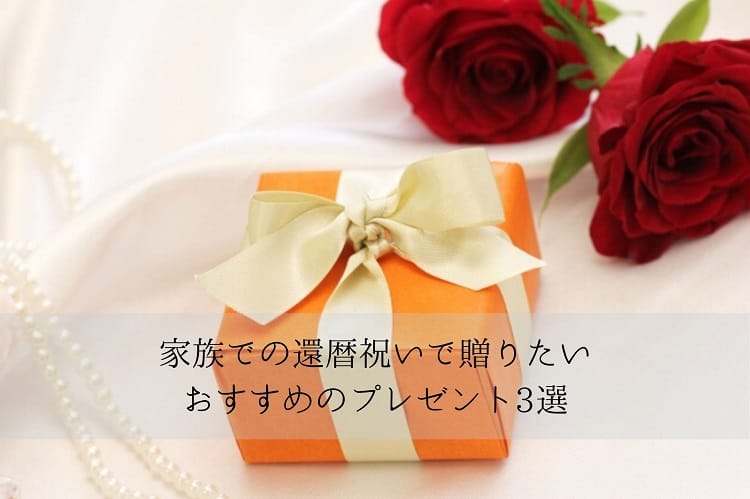 オレンジのプレゼントボックスと2本の赤いバラと真珠のネックレス