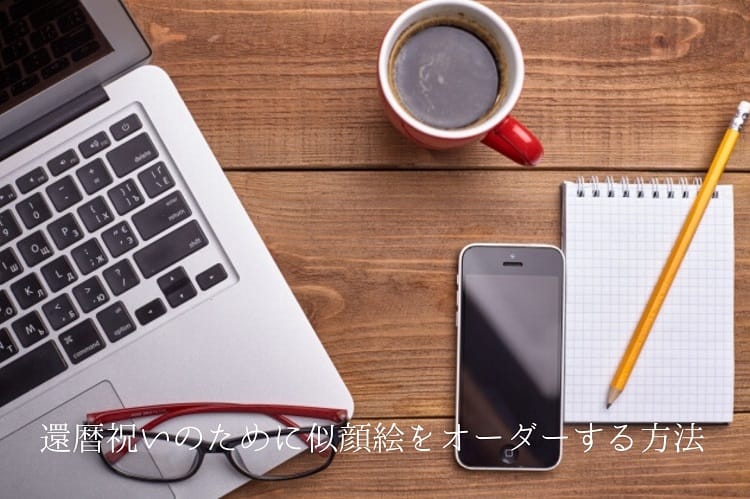 テーブルの上にノートパソコンや鉛筆、スマホ、眼鏡、コーヒーなどが無造作に置かれている