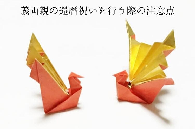 金色とオレンジ色の折り紙で折った2つの折り鶴
