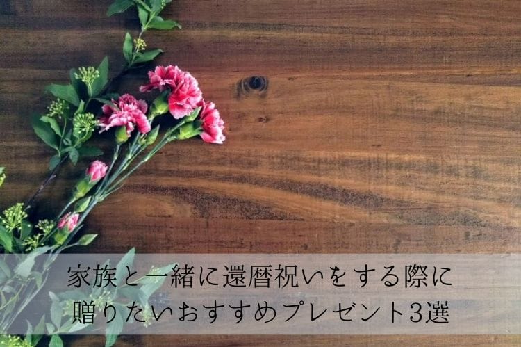 茶色い木のテーブルの上にピンクのカーネーションが数本置かれている