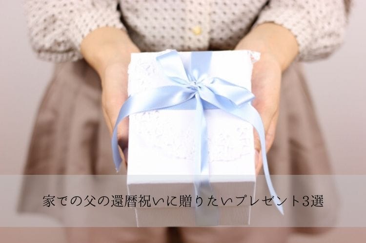 白い包みにブルーのリボンがついたプレゼントボックスを両手で持つ女性