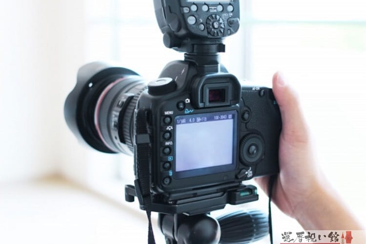 一眼レフカメラを三脚に置き写真を撮ろうとしている様子