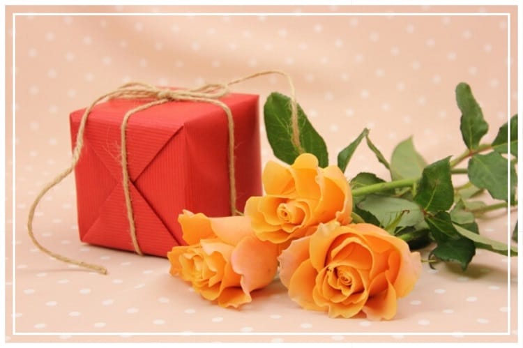 オレンジの薔薇3本と赤い包みに包まれたプレゼントボックス