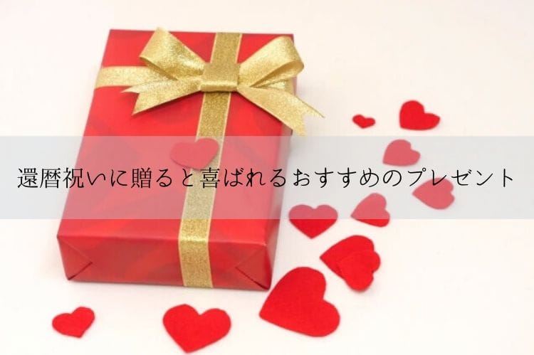 赤の包みにゴールドのリボンがついたプレゼントボックスとフェルトで作ったいくつかの赤いハート