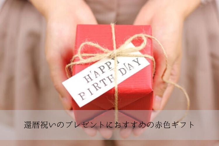 赤いプレゼントボックスを両手で持っている女性の手