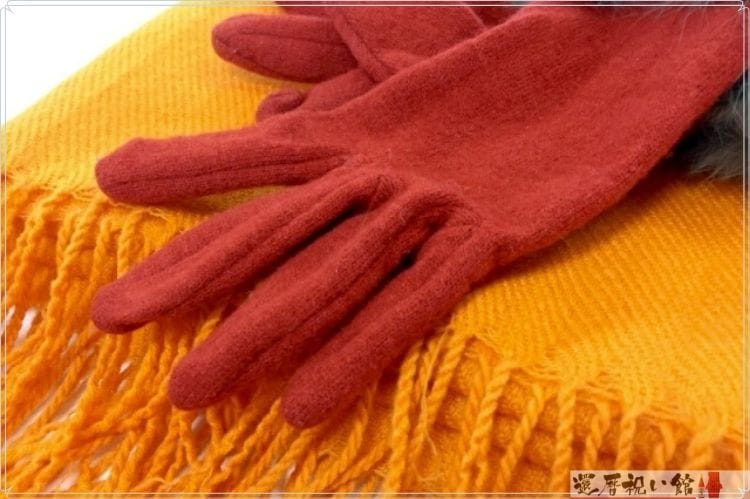 オレンジのマフラーと茶色の手袋