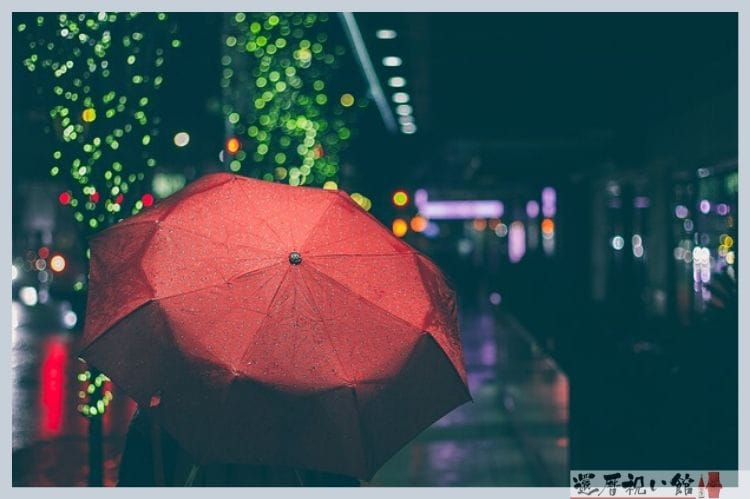 夜の街に照らされた赤い傘