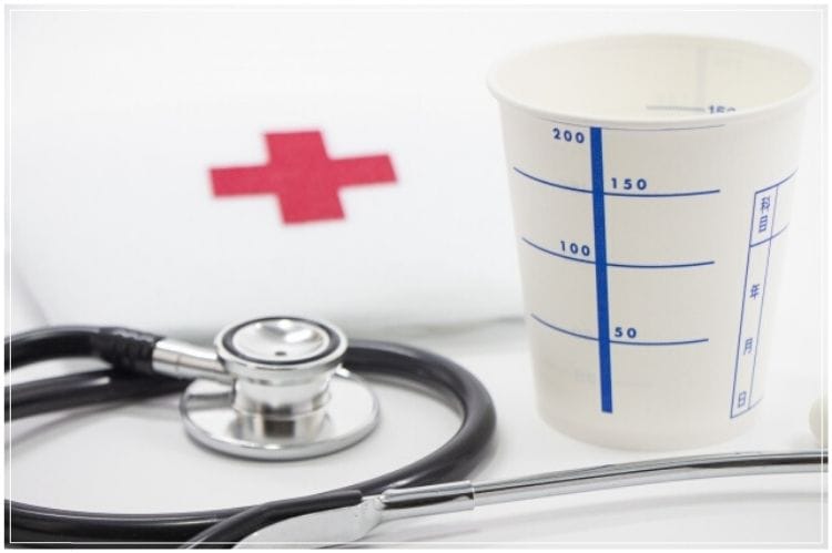 尿検査の紙コップと聴診器と赤十字のマーク