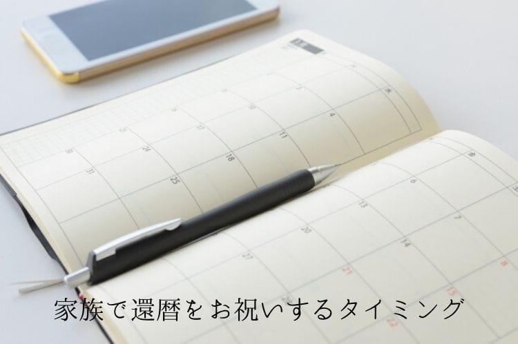 開いた手帳の間にはさまっている黒いボールペンとスマホ