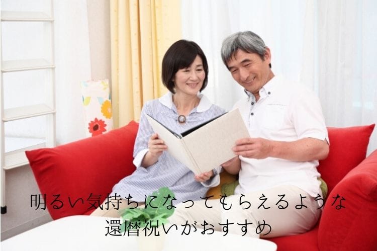 シニア夫婦がソファに座りフォトアルバムを眺めている様子