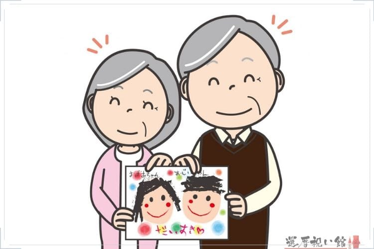シニア夫婦が孫からもらった似顔絵をもって笑顔になっているイラスト